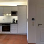 Küche mit neuen Elektrogeräten und Tür zum Flur im Ferienhaus Deichschaf an der Nordsee